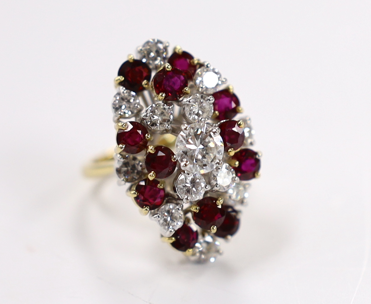 A modern yellow metal, ruby and diamond set oval cluster dress ring, size L/M, gross weight 11.4 grams.